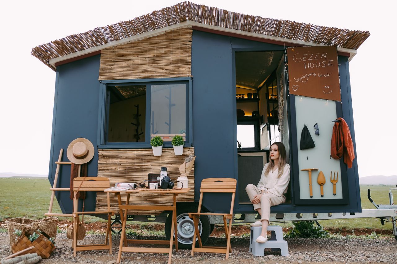 A woman enjoys a peaceful moment in a stylish mobile home, showcasing boho design.